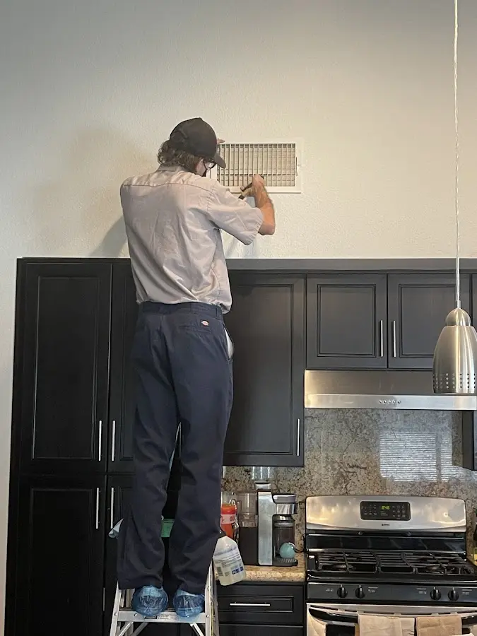 Technician inspecting an air vent during HVAC service in Thief River Falls